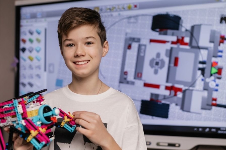 Niño con un modelo robótico construido con legos