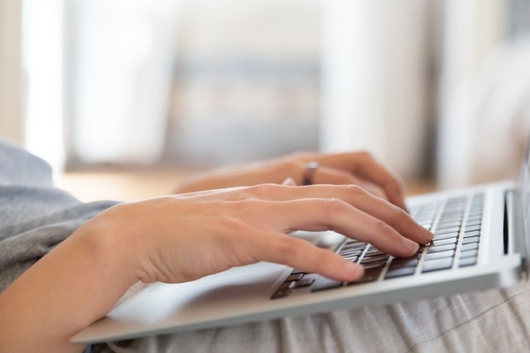 Dos manos sobre las teclas de un teclado de portátil