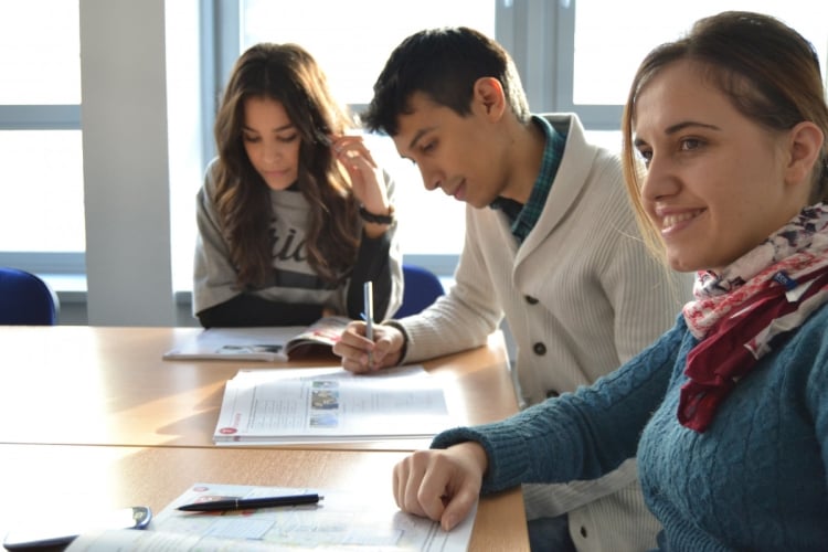 tres estudiantes estudiando alrededor de una mesa