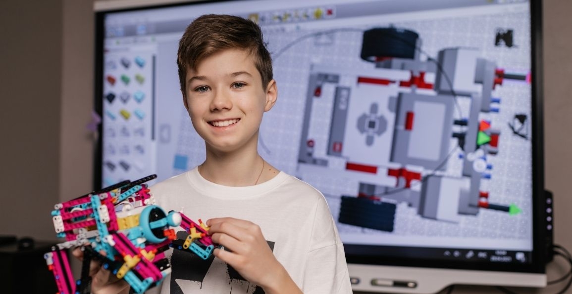 Niño con un modelo robótico construido con legos