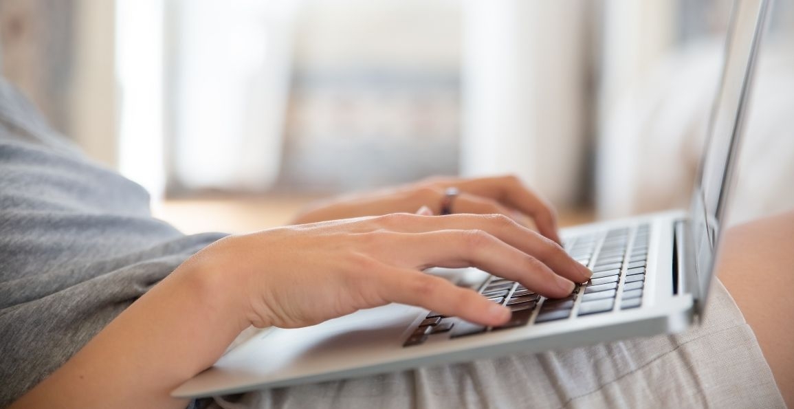 Dos manos sobre las teclas de un teclado de portátil