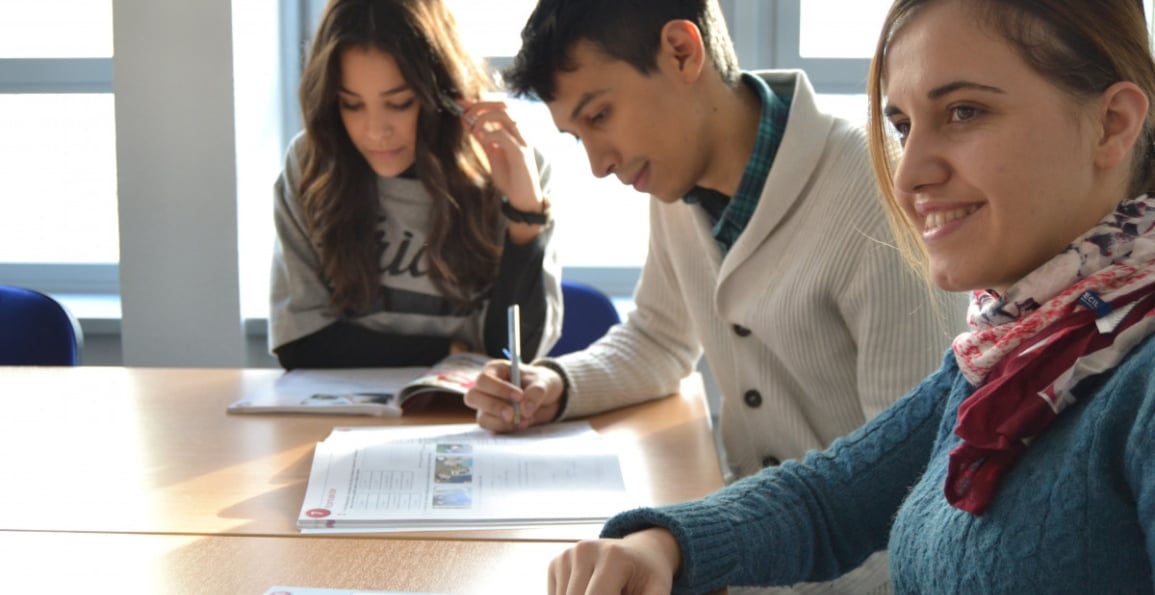 tres estudiantes estudiando alrededor de una mesa