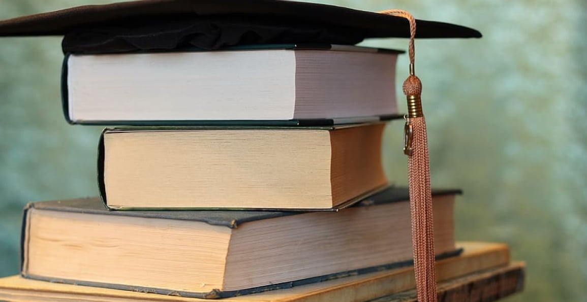 libros con sombrero de graduación 